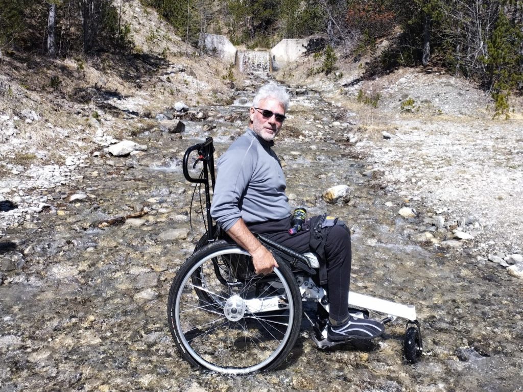 Randonneur en TRACE R en passage à gué dans un ruisseau